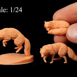 May include: Three miniature fox figurines in a 1/24 scale. The foxes are made of a light peach-coloured material and are posed in different positions. One fox is jumping, another is lying down, and the third is standing. The figurines are on a black background.