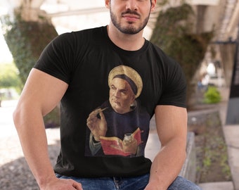 Pode incluir: Uma camiseta preta com uma estampa gráfica de um homem usando um chapéu e segurando um livro e uma caneta. O homem tem barba e está olhando para o espectador.