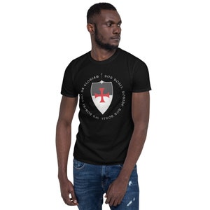 May include: Black t-shirt with a white and black shield with a red cross and the text "Non Nobis, Domine, Non Nobis, Sed Nomini Tuo Da Gloriam" in a circle around the shield.