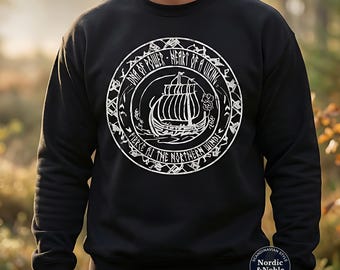 May include: Black sweatshirt with a white circular graphic depicting a Viking ship and the text "DNA OF POWER - HEART OF A VIKING" and "FIERCE AS THE NORTHERN WINDS". The sweatshirt has a crew neck and long sleeves.