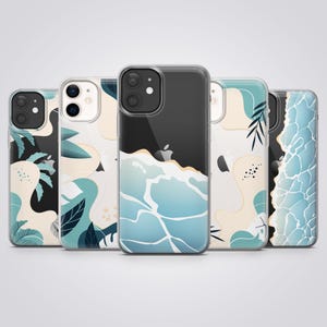 May include: A collection of five clear phone cases with various designs. The cases feature ocean wave, leaf, and abstract patterns in shades of blue, cream, and black. Each case has a transparent border, showcasing the phone's design.