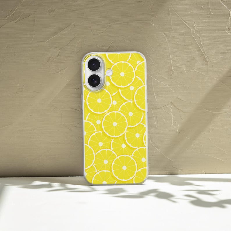 May include: A clear phone case with a yellow lemon slice pattern. The case has a cutout for the camera lens.