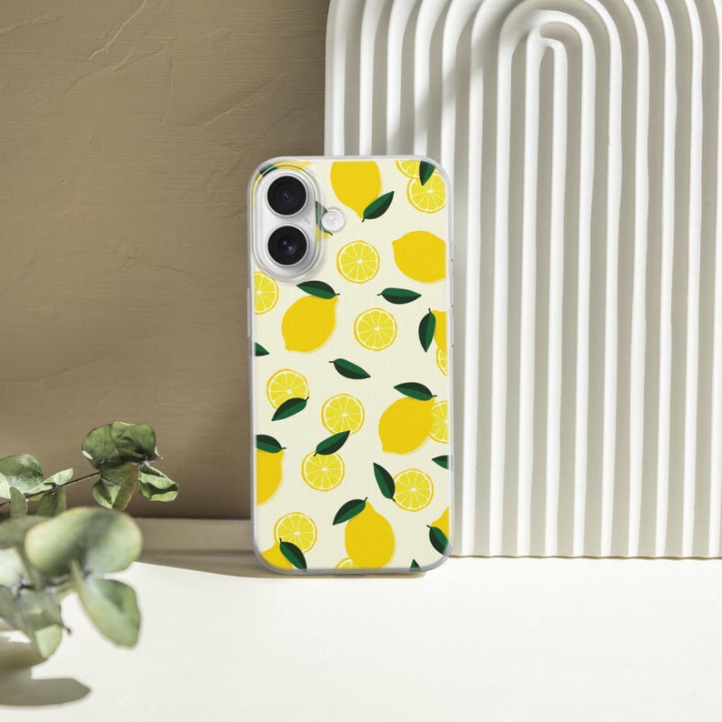May include: A clear phone case with a pattern of yellow lemons and green leaves on a white background.