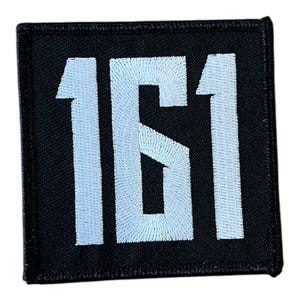 Könnte beinhalten: Quadratischer schwarzer Aufnäher mit den weiß gestickten Zahlen "161". Die Zahlen sind in einer fetten, serifenlosen Schriftart gehalten. Der Aufnäher hat einen schwarzen Rand und ist wahrscheinlich aus Stoff.