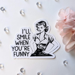 Könnte beinhalten: Schwarz-weißer Aufkleber mit einer Retro-Frauenillustration und dem Text "I'll smile when you're funny".