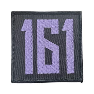 Könnte beinhalten: Quadratischer schwarzer Aufnäher mit der Zahl "161" in Lavendel gestickt. Der Aufnäher hat einen schwarzen Rand und ist zum Aufnähen oder Aufbügeln auf Stoff vorgesehen. Die Zahlen sind groß und gut lesbar.