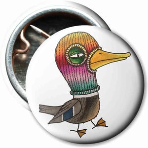 Könnte beinhalten: Eine Comic-Ente trägt eine bunte Strickmütze. Die Mütze ist regenbogenfarben und hat einen weißen Rand. Die Ente schaut nach rechts und hat einen gelben Schnabel.