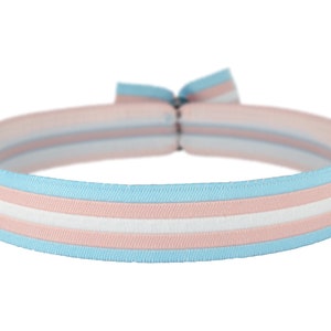 Könnte beinhalten: Ein elastisches Stirnband mit hellblauen, weißen und rosa Streifen.