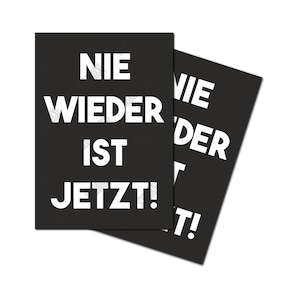 Könnte beinhalten: Zwei schwarze Karten mit weißem Text, der "NIE WIEDER IST JETZT!" lautet. Die Karten liegen übereinander, wobei die obere Karte leicht nach rechts versetzt ist.