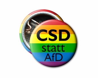 May include: A rainbow-colored button with the text "CSD statt AfD" in black letters.