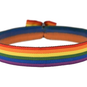 Könnte beinhalten: Ein elastisches Regenbogenarmband mit schwarzem Rand. Das Armband zeigt die Farben Rot, Orange, Gelb, Grün, Blau und Lila.