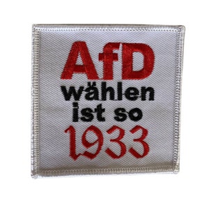 Könnte beinhalten: Weißer quadratischer Patch mit rotem gesticktem Text, der "AfD wählen ist so 1933" lautet.