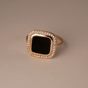Gold plated ring with square shaped black agate stone surrounded by white zirconium oxides