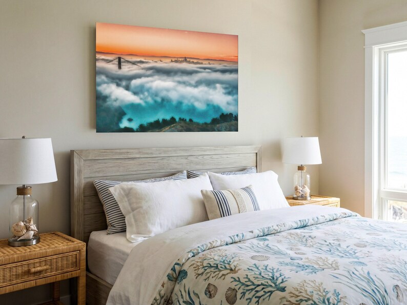 May include: A rectangular wall art print featuring a landscape of the Golden Gate Bridge partially obscured by a thick layer of low-hanging clouds under a vibrant orange sunset sky, with dark green hills visible in the foreground.