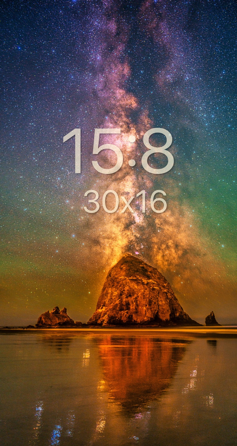 May include: A night sky photograph featuring a large rock formation on a beach reflecting in the wet sand. The Milky Way galaxy is visible above with purple, orange, and green hues. The text 15:8 and 30x16 is centred in the upper portion.