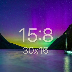 May include: A scenic landscape photograph featuring a lake with a sailboat, mountains, and a vibrant night sky. The sky displays a colorful aurora borealis effect. Text on the image reads "15:8" and "30x16".