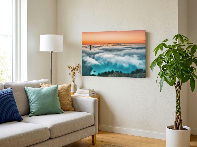 May include: A rectangular wall art print featuring a landscape photograph of the Golden Gate Bridge partially obscured by a thick layer of low-hanging clouds, with a vibrant orange sunset sky above and a deep blue hue in the shadowed areas.