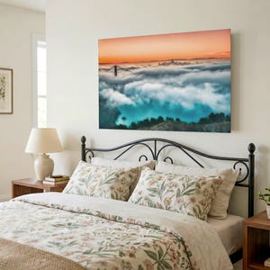 May include: A rectangular wall art print featuring a landscape photograph of the Golden Gate Bridge partially obscured by a thick layer of fog, with a vibrant orange sunset sky above and dark green hills visible in the foreground below the clouds.