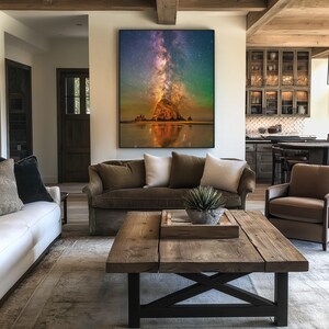 May include: A large rectangular wall art print featuring a vibrant night sky with a glowing purple and orange nebula above a dark rock formation on a beach, with the reflection of the scene visible in the calm water below the horizon line.