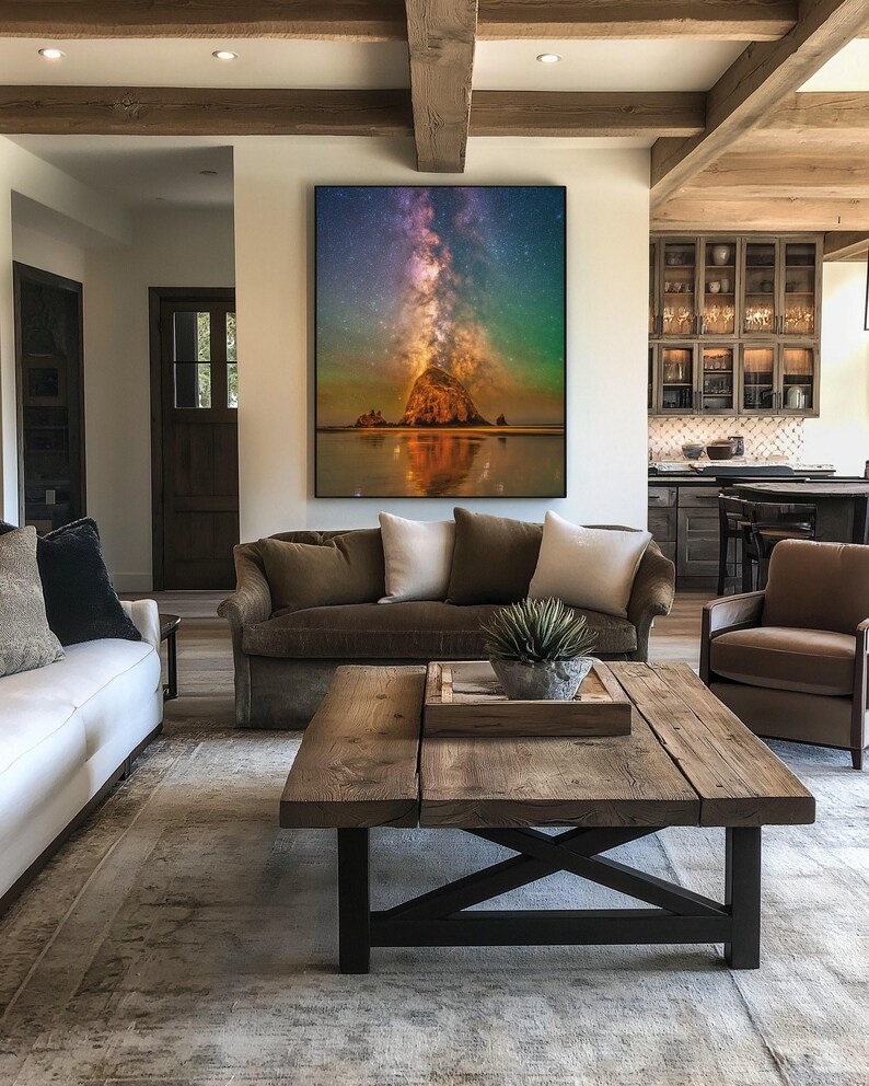 May include: A large rectangular wall art print featuring a vibrant night sky with a glowing purple and orange nebula above a dark rock formation on a beach, with the reflection of the scene visible in the calm water below the horizon line.