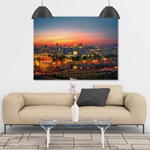 Puede incluir: Una vista a&eacute;rea de Jerusal&eacute;n al atardecer, con la C&uacute;pula de la Roca y el Muro de las Lamentaciones iluminados. La ciudad est&aacute; ba&ntilde;ada por una c&aacute;lida luz dorada, con el cielo de un vibrante naranja y rosa.