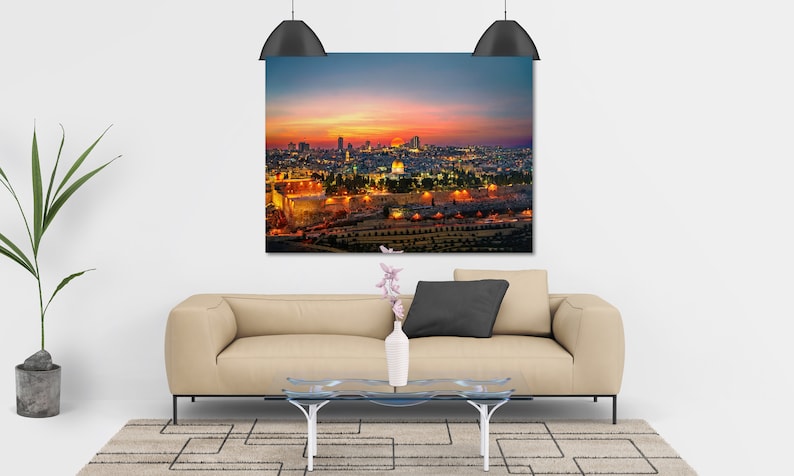 Puede incluir: Una vista a&eacute;rea de Jerusal&eacute;n al atardecer, con la C&uacute;pula de la Roca y el Muro de las Lamentaciones iluminados. La ciudad est&aacute; ba&ntilde;ada por una c&aacute;lida luz dorada, con el cielo de un vibrante naranja y rosa.