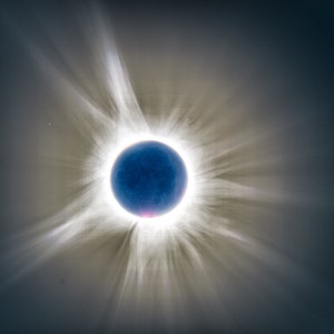 May include: A total solar eclipse showing the sun's corona as a bright white halo around the dark silhouette of the moon.