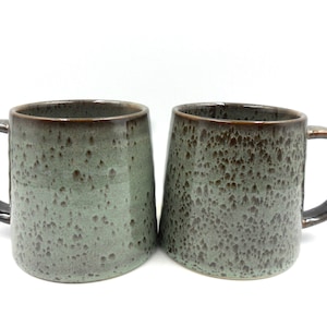 2 x Reactive Glaze Cuddly Brûlée Stoneware mugs in misty green with coffee speckles.