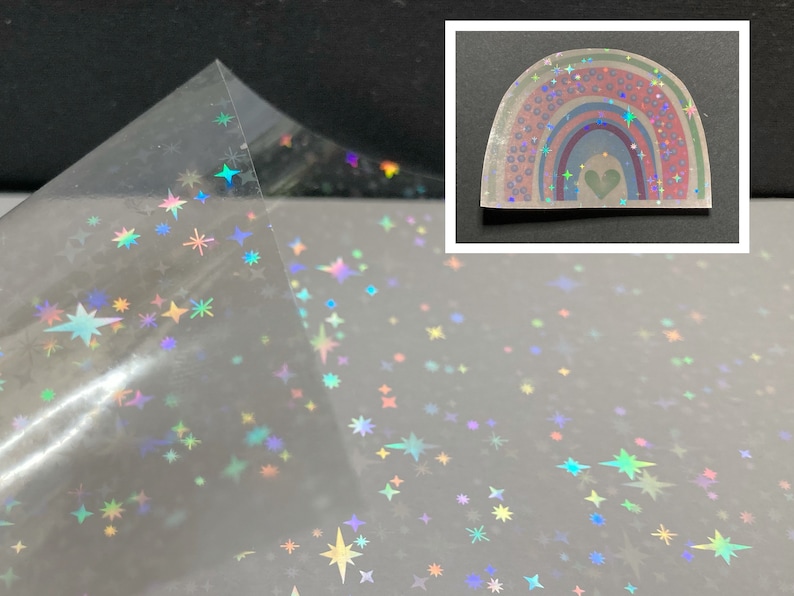 May include: A sheet of iridescent holographic vinyl with a scattered star pattern. The vinyl is clear and has a rainbow sheen. A separate image shows a rainbow with a heart in the center, also made of iridescent holographic vinyl.