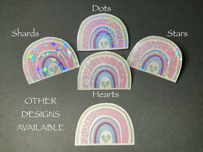 May include: Five rainbow stickers with different holographic designs: dots, shards, stars, hearts, and a design with small circles. Each sticker features a rainbow with a small heart in the center.