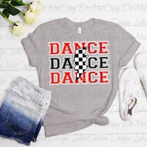May include: A gray t-shirt with a red, black, and white graphic design that says "DANCE DANCE DANCE" with a checkered flag and lightning bolt.
