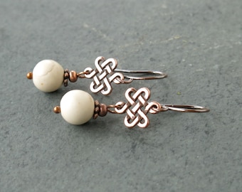 May include: A pair of copper earrings with white howlite beads and a Celtic knot design.