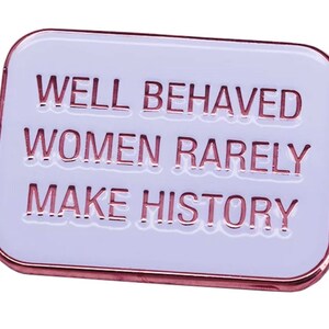 May include: White enamel pin with a rose gold border. The pin features the text "WELL BEHAVED WOMEN RARELY MAKE HISTORY".