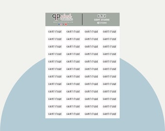 May include: A sheet of 48 black script stickers with the word "gratitude" printed on each sticker. The stickers are arranged in a grid pattern on a white background.
