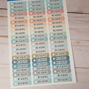 May include: A sheet of colorful planner stickers with the word "READING" printed on each sticker. The stickers are in various shades of blue, green, yellow, orange, and pink.