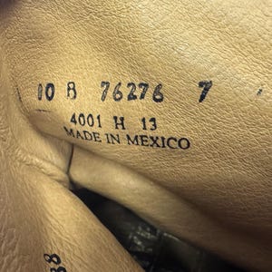 May include: Close-up of the inside of a leather boot. The boot's interior is a light tan color, with visible stitching and texture. Black text includes numbers and the words "MADE IN MEXICO".