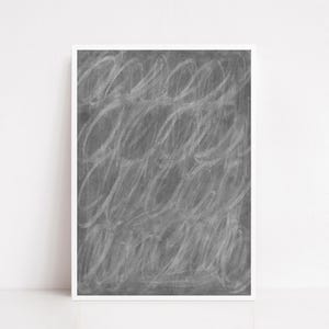 Puede incluir: Una impresión artística abstracta enmarcada. La obra presenta un fondo gris con formas ovaladas blancas garabateadas. La impresión se muestra en un marco blanco, creando una estética minimalista. Adecuada para la decoración.