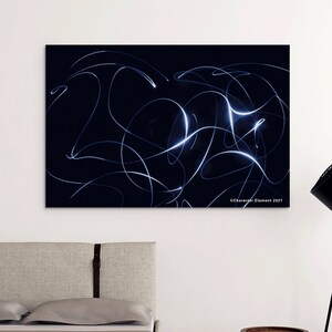 May include: Abstract art print featuring white lines on a black background. The print is hanging on a white wall in a modern living room setting.