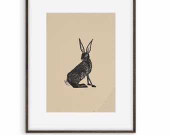 May include: A framed art print showing a black illustration of a hare. The hare is depicted in a seated position with long ears and a fluffy tail. The artwork is set against a beige background, framed in a dark brown frame.