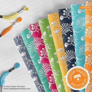 May include: A set of eight dinosaur skeleton patterned fabric sheets in various colors, including teal, green, yellow, orange, red, and blue. The fabric sheets are arranged in a fan shape and feature a white dinosaur skeleton pattern. The fabric sheets are labeled with the text "Little Paper Boutique".