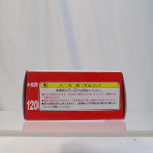May include: A red rectangular box with Japanese text and the number 120. The box has a white background and a warning label. The text on the box is in Japanese.