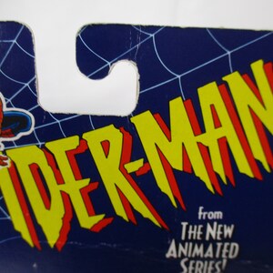 Pu&ograve; includere: Un logo di Spider-Man blu e giallo con il testo "From The New Animated Series!" su uno sfondo blu con un motivo a ragnatela.