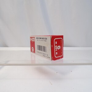 May include: A red and white box with Japanese text and the number 9. The box is for a Komatsu Power Shovel PC200. The box has a barcode and the number 6 on the side. Made in Japan.