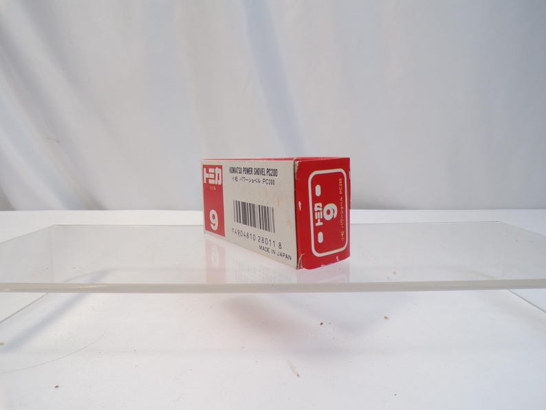 May include: A red and white box with Japanese text and the number 9. The box is for a Komatsu Power Shovel PC200. The box has a barcode and the number 6 on the side. Made in Japan.