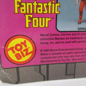 May include: A pink and gray cardboard box with a yellow and red Toy Biz logo. The box features the text "Fantastic Four" and "Gorgon". The text "Marvel Comics, Ironman and all characters, their distinctive likeness are trademarks of Marvel Entertainment Group, Inc. and are used with permission." is printed on the box.