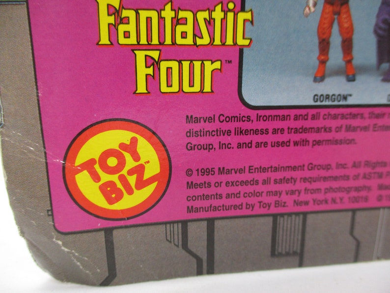 May include: A pink and gray cardboard box with a yellow and red Toy Biz logo. The box features the text "Fantastic Four" and "Gorgon". The text "Marvel Comics, Ironman and all characters, their distinctive likeness are trademarks of Marvel Entertainment Group, Inc. and are used with permission." is printed on the box.