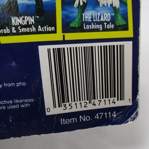 Pu&ograve; includere: Una carta di action figure blu e gialla con un codice a barre e il testo "KINGPIN TM Grab & Smash Action" e "THE LIZARD TM Lashing Tale" e "Item No. 47114".