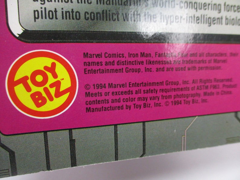 May include: A close-up of a product package with the Toy Biz logo in a yellow circle with a red border. The text includes Marvel Comics, Iron Man, and copyright information from 1994.