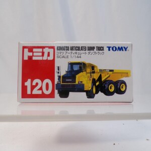 May include: A toy box featuring a yellow Komatsu articulated dump truck model. The box has the number 120 in white on a red background, with Japanese text and the TOMY logo. The truck is a scale model.