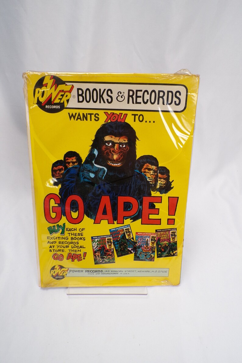 May include: A yellow and black advertisement for Power Records featuring a large ape with the text "GO APE!" and images of Planet of the Apes books and records. The text "WANTS YOU TO..." is above the ape.